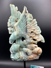 Load image into Gallery viewer, Carved stone sculpture of a bird and a person on a dark background
